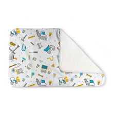Load image into Gallery viewer, Kanga Care Changing Pad and Sheet Saver in the print called Nuts + Bolts with a white background and a colorful construction-themed pattern, shown with one corner folded over to reveal a solid white reverse side.