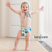 Load image into Gallery viewer, Baby in a bonnet wearing a Rumparooz One Size Cloth Pocket Diaper in the Clover print on size Meidum