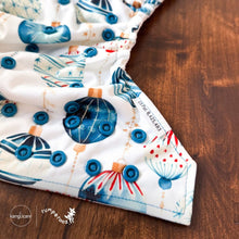 Load image into Gallery viewer, Rumparooz One Size Cloth Diaper laying open on table showing blue snaps in Christmas print called Glaskugeln with blue and red ornament pattern on a white background