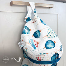 Load image into Gallery viewer, Kanga Care wet bag mini with blue zipper and shell pattern on a neutral background print Glaskugeln with blue and red ornament pattern on a white background