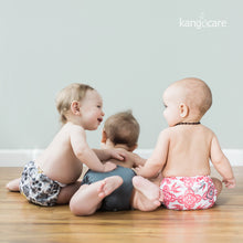 Load image into Gallery viewer, three babies sitting and laying on the floor wearing Rumparooz. Left to right they are wearing Unity, Castle, and Destiny
