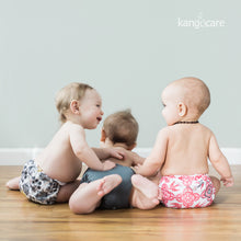 Load image into Gallery viewer, Three babies sitting and laying on the floor wearing Rumparooz. Left to right they are wearing Unity, Castle, and Destiny