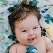 Load image into Gallery viewer, Smiling baby laying on a Clover blanket