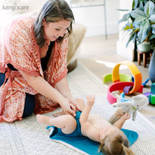 Load image into Gallery viewer, Mom changing baby on a Caribbean Changing Pad