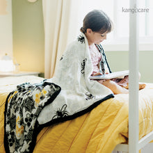 Load image into Gallery viewer, Child wrapped in a Unity Forever Blanket on their bed