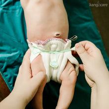 Load image into Gallery viewer, Baby laying on a Peacock changing pad wearing a prefold