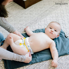 Load image into Gallery viewer, Baby laying on a Kanga Care Changing Pad in a Prefold