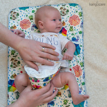 Load image into Gallery viewer, Hands seen putting a Sunshower Rumparooz on a baby laying on a Sunshower Changing Pad
