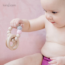 Load image into Gallery viewer, Baby sitting in a Boysenberry Ecoposh OBV, holding a Blush teething ring