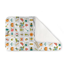 Load image into Gallery viewer, Kanga Care Changing Pad and Sheet Saver in the print called Bloom with a colorful garden-themed pattern on a white and gray checkered background, folded to show a soft white fleece backing, on a solid white background.
