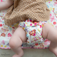 Load image into Gallery viewer, Candylicious Rumparooz One Size Pocket Cloth Diaper on a baby laying on a Kanga Care changing pad in the Candylicious print
