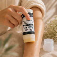 Load image into Gallery viewer, Person applying a stick of body wax from Grovia on their arm with a blurred natural background.
