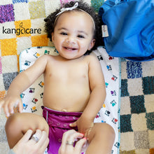 Load image into Gallery viewer, Smiling baby laying on an I Love RAR changing pad, wearing a Boysenberry Rumparooz OBV, with a nearby Nautical Wet Bag
