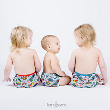 Load image into Gallery viewer, three young children sit side by side, each in a WeeHoo diaper cover with different trim colours (red, white, blue)
