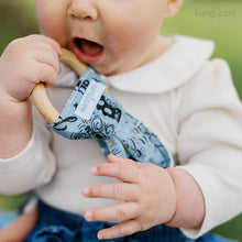 Load image into Gallery viewer, Baby holding a Wander Bunny Ear Teething Ring, bringing it to their mouth
