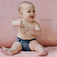 Load image into Gallery viewer, Baby sitting in a Castle Rumparooz cover, holding a Blush teething ring
